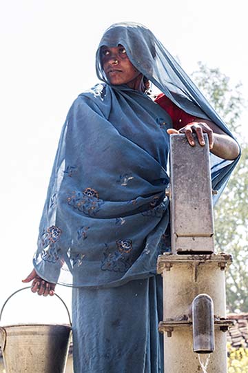 Indian woman next to a well