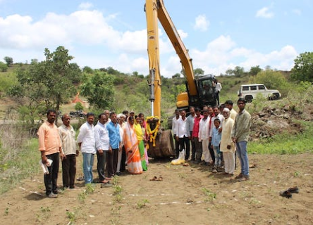 Equipe de Rain Drop et villageois devant un engin de chantier